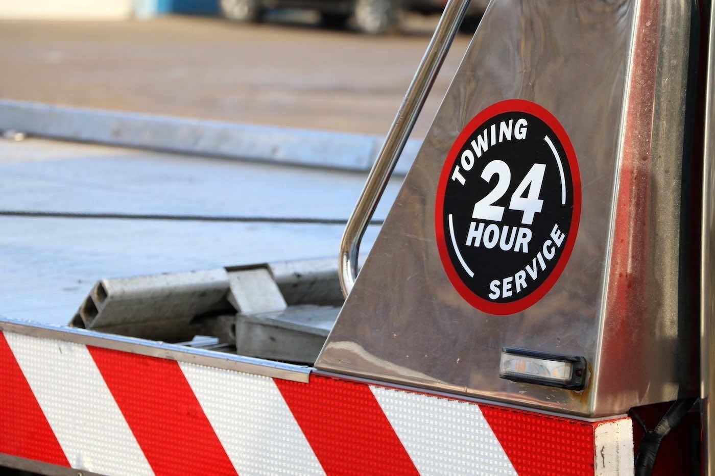 A driver reviewing a tow invoice on a roadside shoulder next to a tow truck