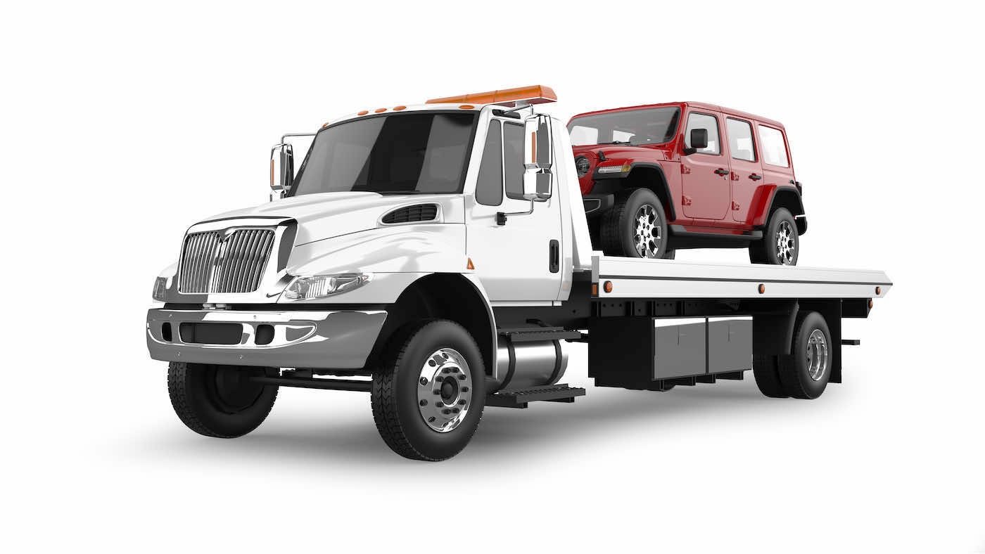 Flatbed tow truck carrying an SUV